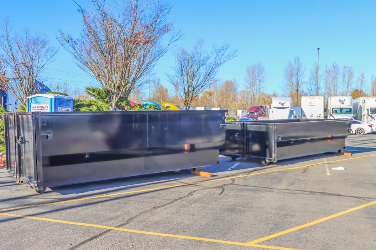 Professional dumpster rental service with roll-off container on residential driveway in Pebble Creek